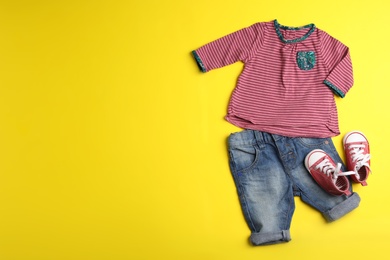 Photo of Flat lay composition with cute clothes and space for text on color background. Baby accessories