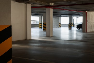 Open car parking garage, focus on column with warning stripes