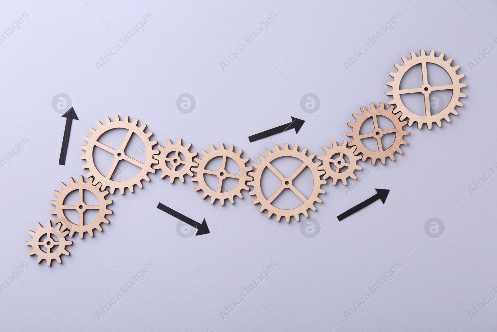 Photo of Business process organization and optimization. Scheme with wooden figures and arrows on lilac background, top view