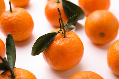 Fresh ripe tangerines with leaves on white background, closeup