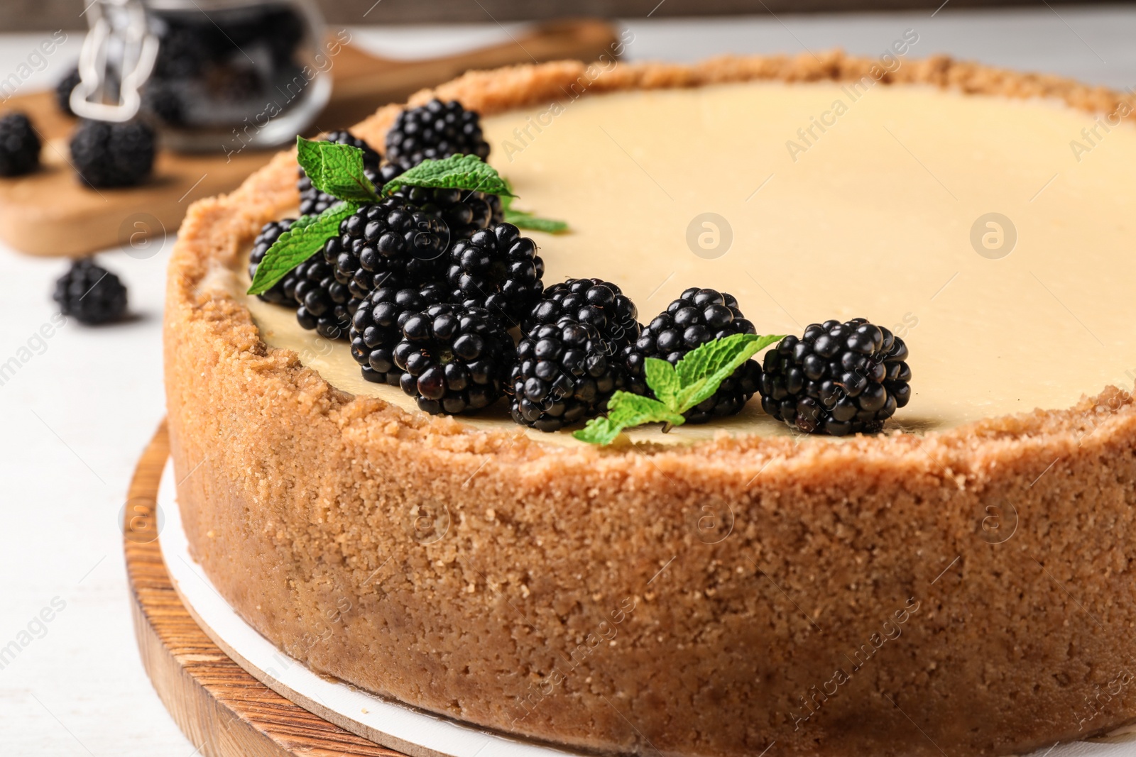 Photo of Delicious cheesecake decorated with blackberries on table