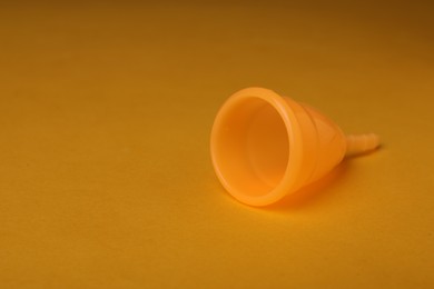 Photo of Menstrual cup on yellow background. Space for text