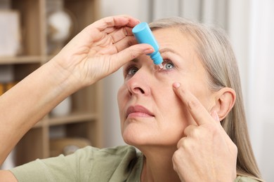 Photo of Woman applying medical eye drops at home