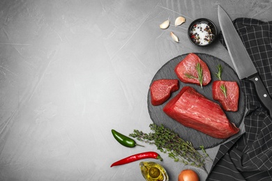 Photo of Flat lay composition with fresh raw meat, products and space for text on gray background