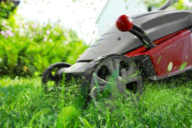 Image of Lawn mower on green grass in garden, closeup
