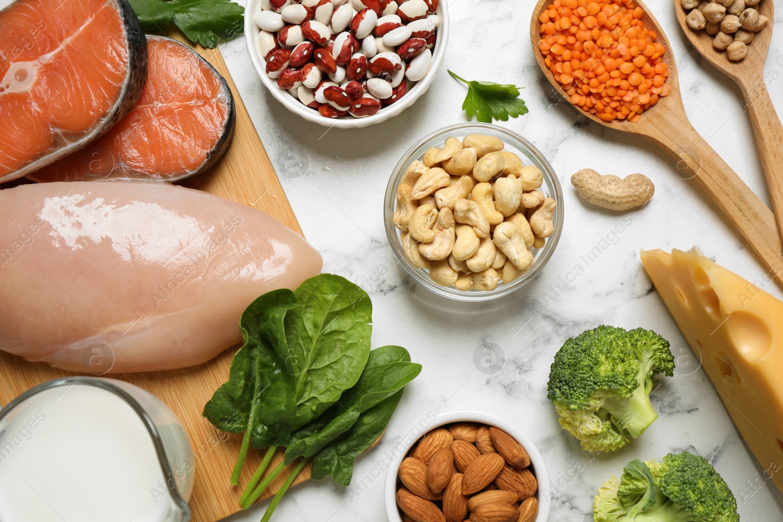 Photo of Products rich in protein on white marble table, flat lay