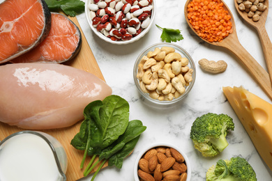 Products rich in protein on white marble table, flat lay