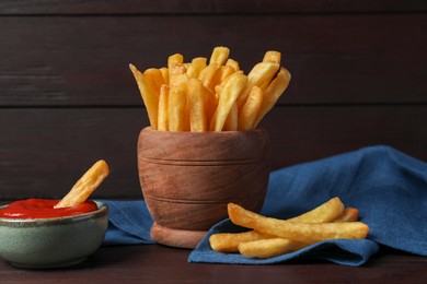 Bowl of french fries with ketchup on black table