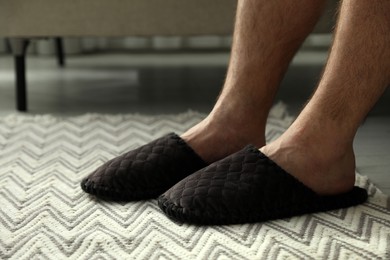 Photo of Man in soft slippers at home, closeup