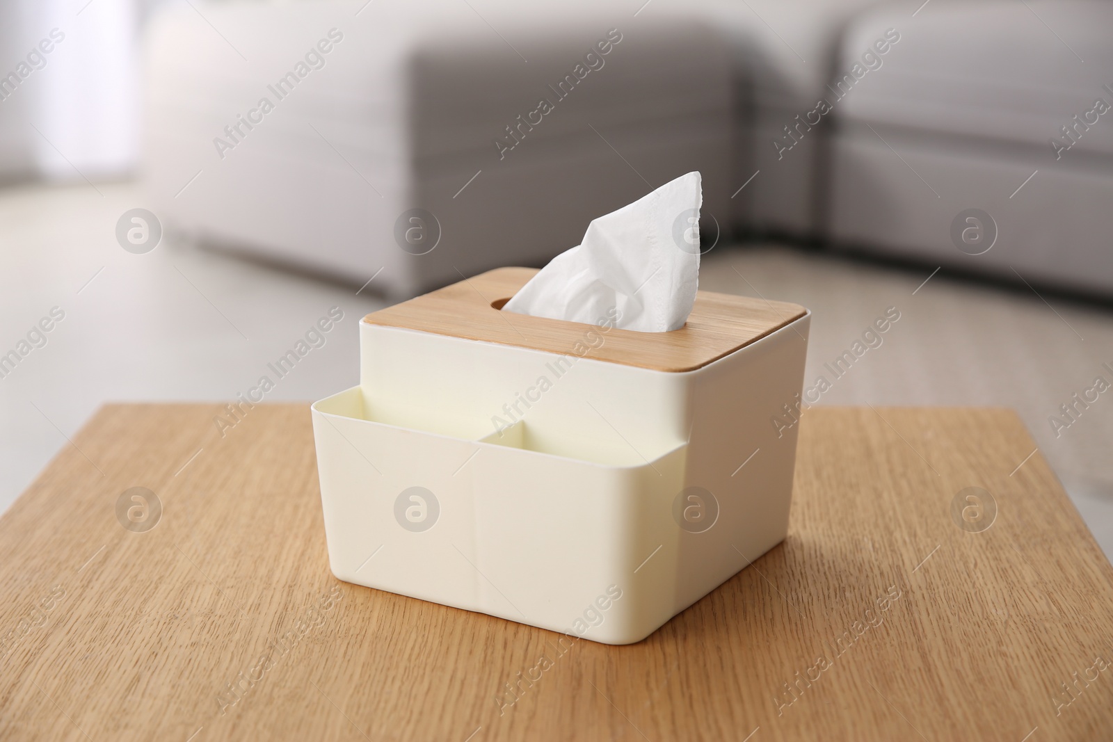 Photo of Box with paper tissues on wooden table in living room