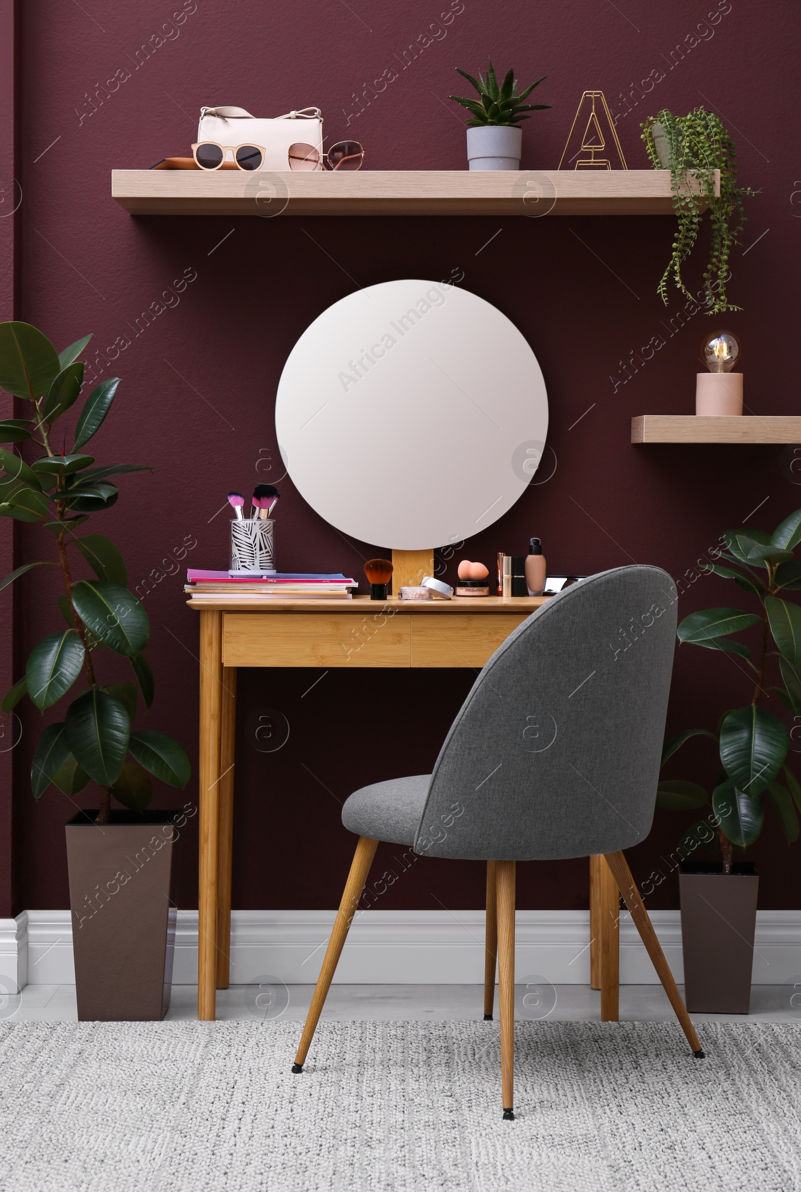 Photo of Wooden dressing table and chair near brown wall in room