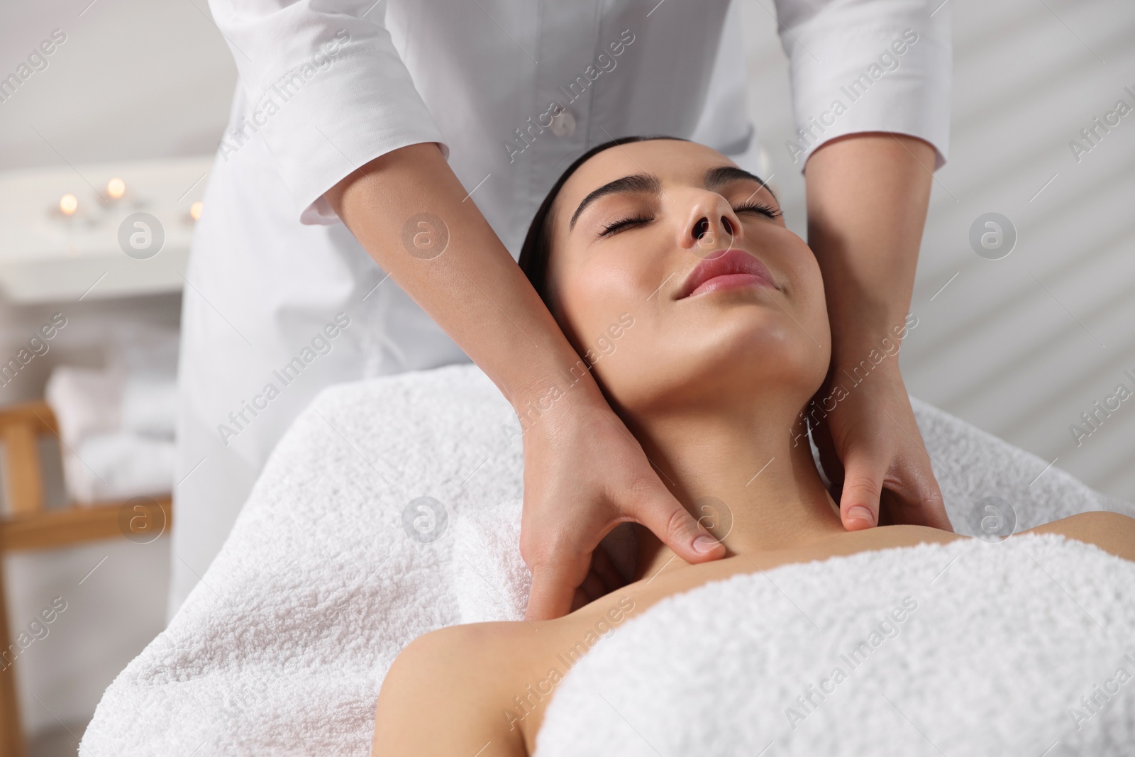 Photo of Beautiful woman receiving massage in beauty salon, closeup