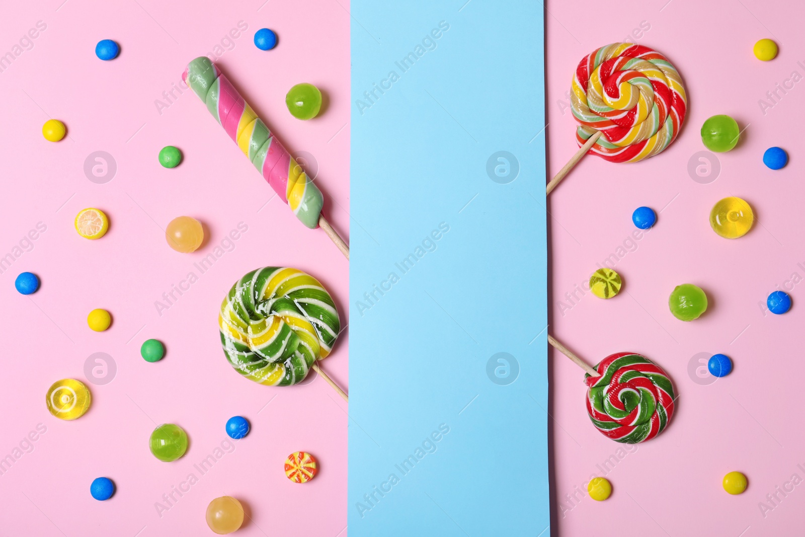 Photo of Different tasty candies and card with space for text on color background, flat lay