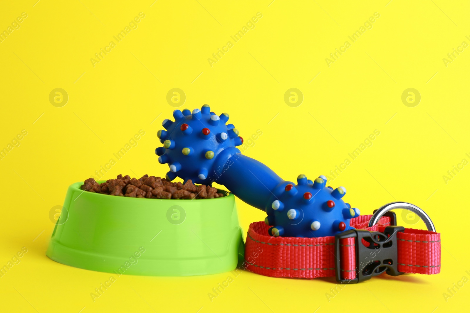 Photo of Pet toy, collar, food and feeding bowl on yellow background