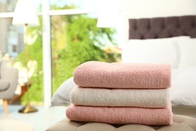 Stack of soft clean terry towels on bedside bench. Space for text