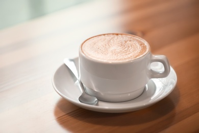 Cup of aromatic coffee on wooden table