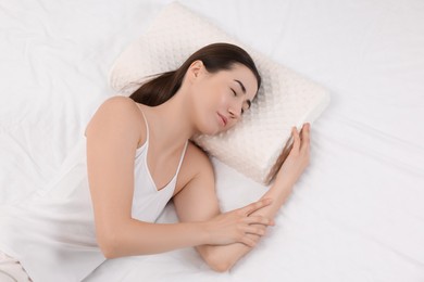 Photo of Woman sleeping on orthopedic pillow in bed