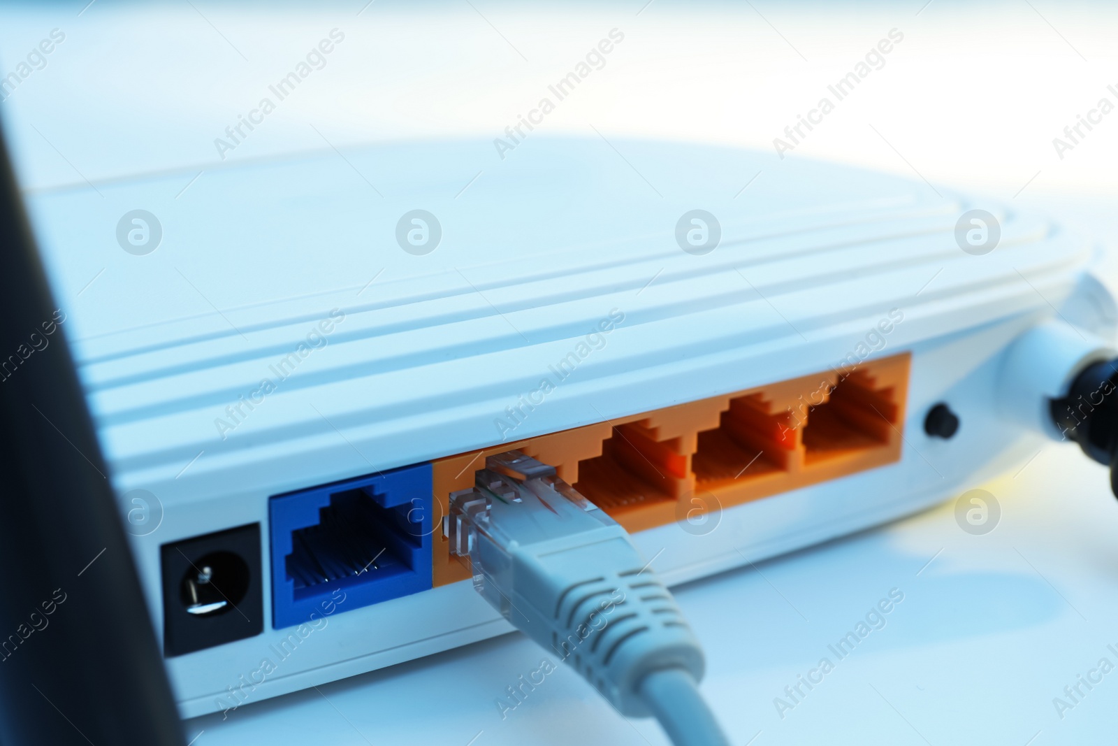 Photo of Connected cable to router on white table, closeup. Wireless internet communication