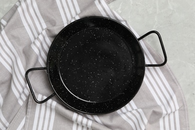 Photo of Serving pan and tablecloth on grey marble table, flat lay. Cooking utensil