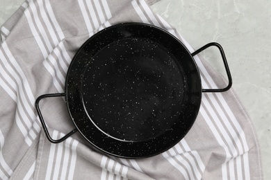 Serving pan and tablecloth on grey marble table, flat lay. Cooking utensil