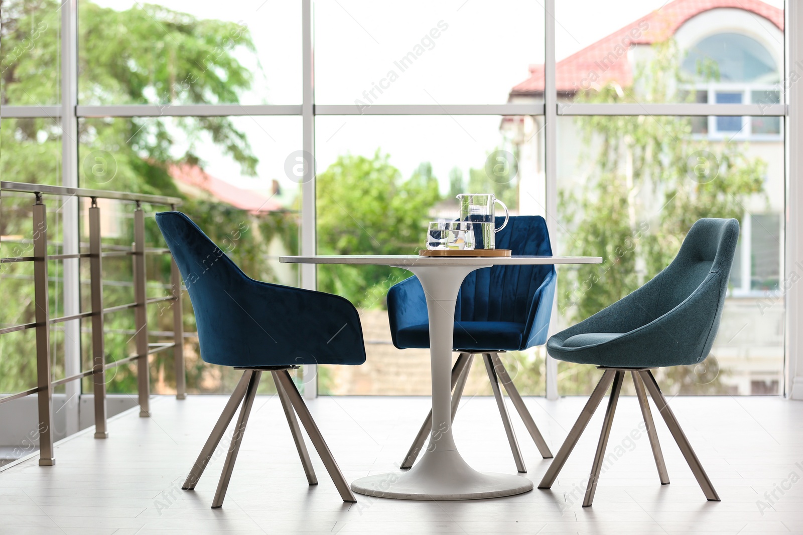 Photo of Stylish room interior with round table and comfortable chairs