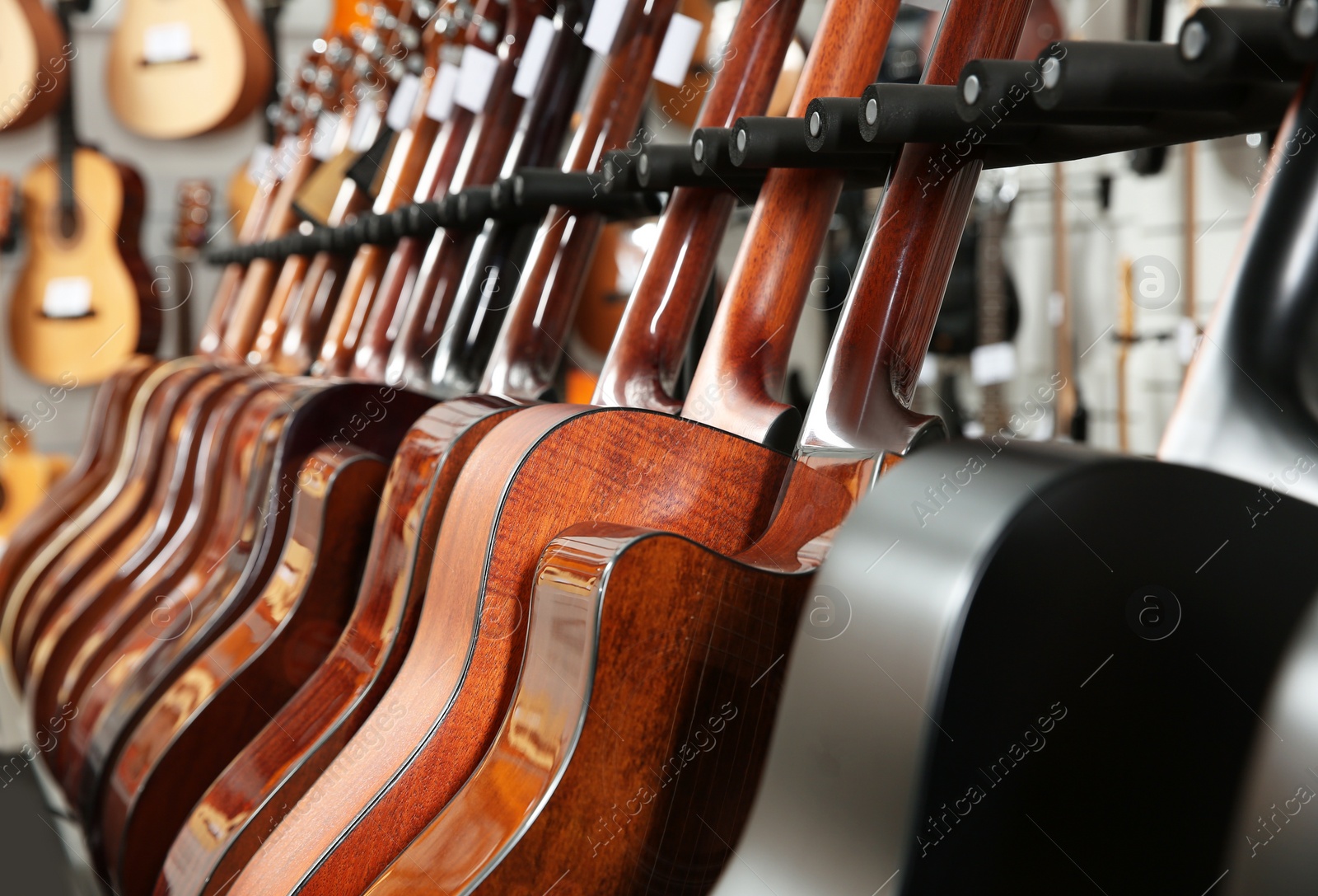 Photo of Row of different guitars in music store, closeup