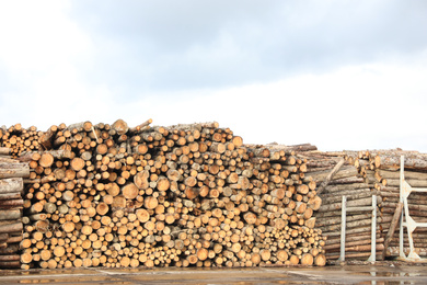 Photo of Stacked firewood outdoors. Heating house in winter