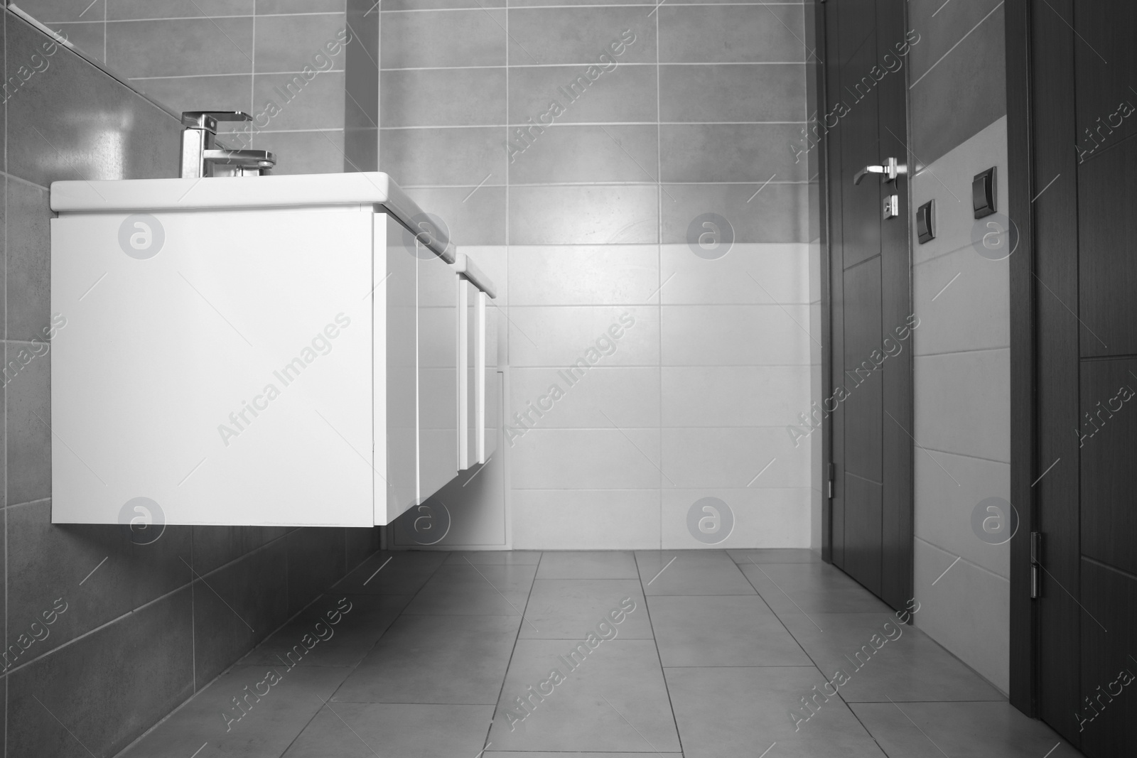 Photo of Beautiful clean sinks near mirror in public toilet