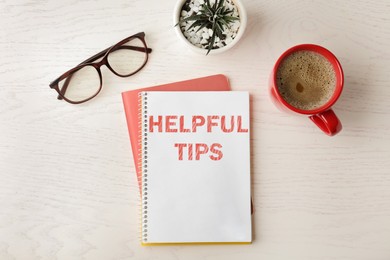 Notebook with text Helpful Tips on wooden table, flat lay