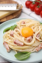 Photo of Delicious pasta Carbonara with egg yolk on table, closeup