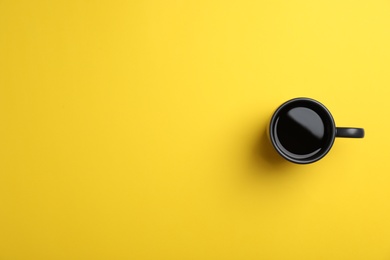 Ceramic cup with hot aromatic coffee on color background, top view