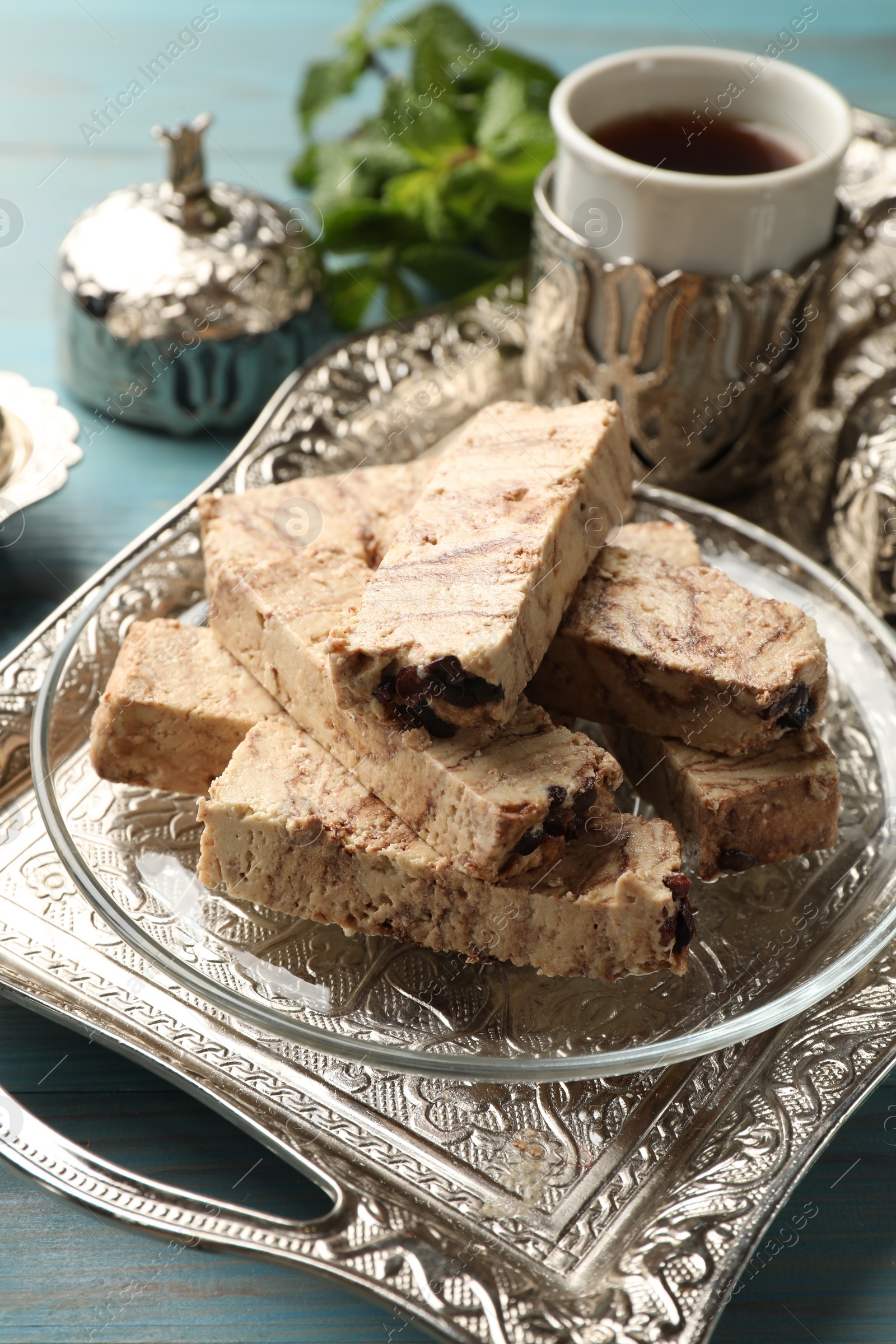 Photo of Tasty chocolate halva on light blue wooden table