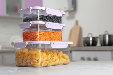 Stacked boxes with different food on table in kitchen, space for text