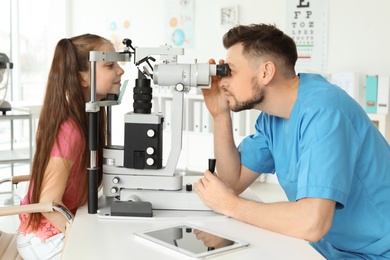 Ophthalmologist examining little girl in clinic