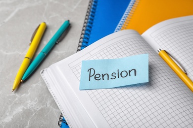 Paper with word PENSION on page of open notebook