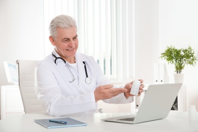 Doctor consulting patient using video chat on laptop in clinic