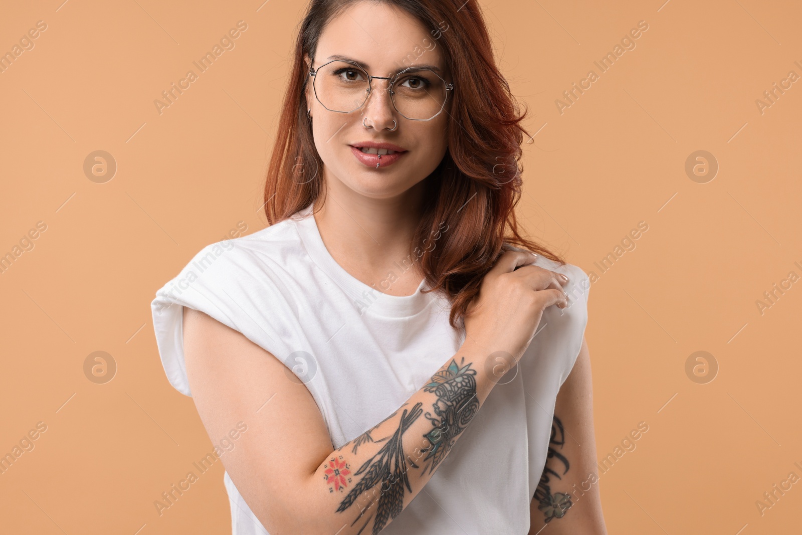 Photo of Portrait of beautiful tattooed woman on beige background