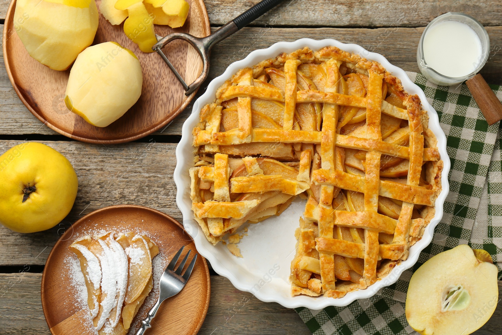 Photo of Tasty homemade quince pie, ingredients, peeler and fork on wooden table, flat lay