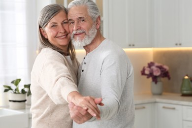 Photo of Senior couple spending time together in kitchen