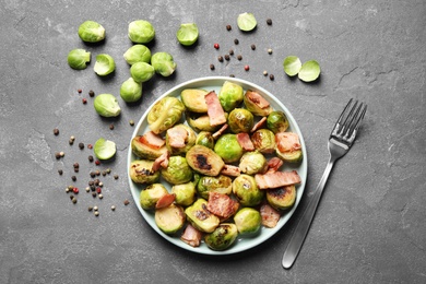 Image of Delicious fried Brussels sprouts with bacon served on grey table, flat lay