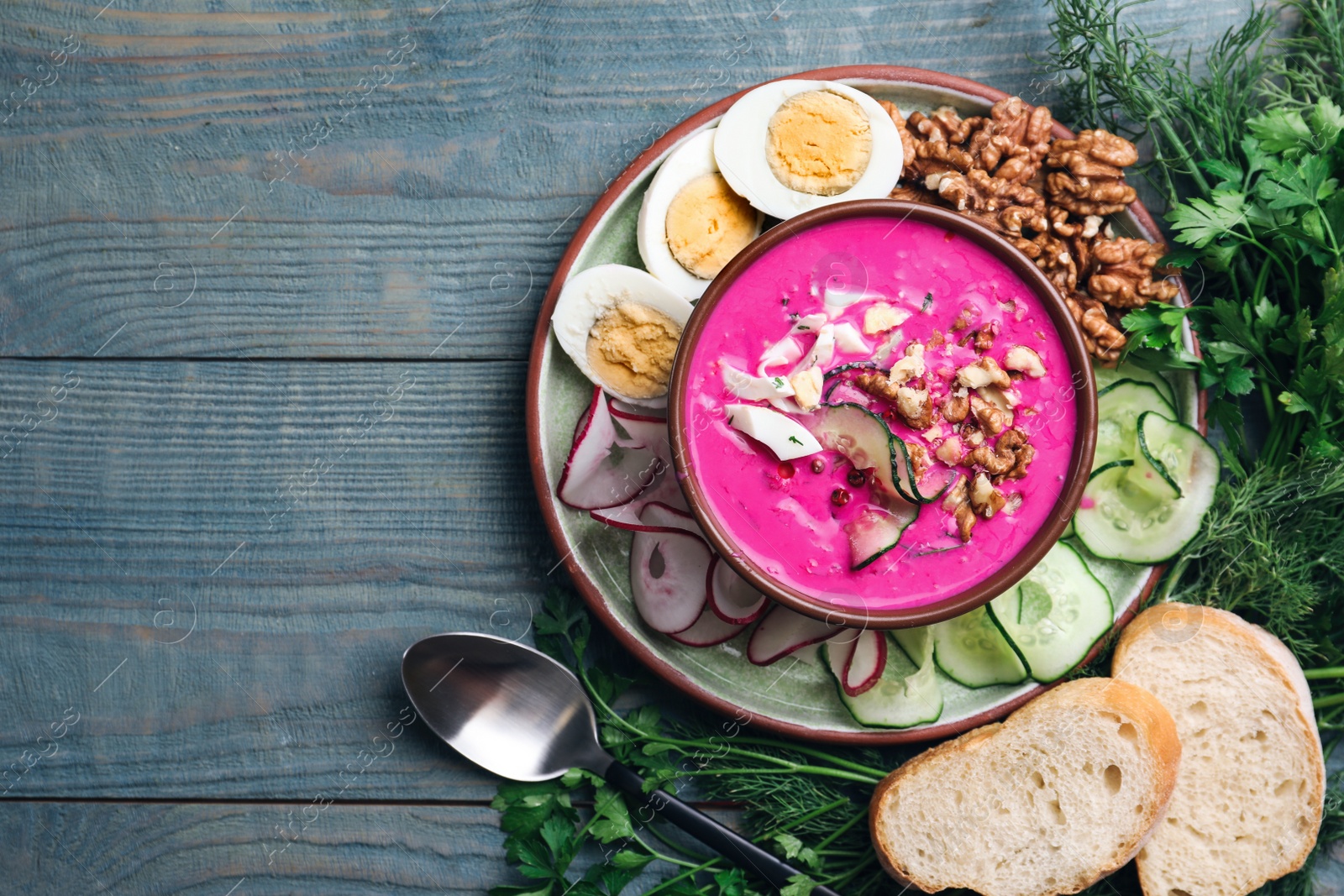 Photo of Delicious cold summer beet soup on blue wooden table, flat lay. Space for text