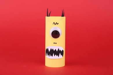 Spooky paper monster on red background. Handmade Halloween decoration