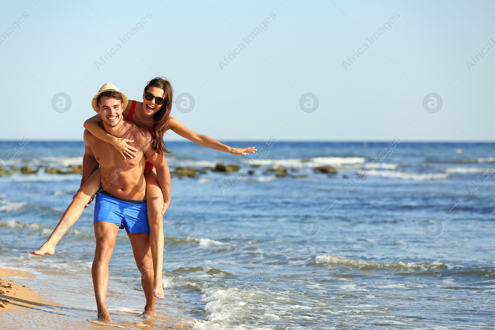 Photo of Happy young couple having fun at beach on sunny day