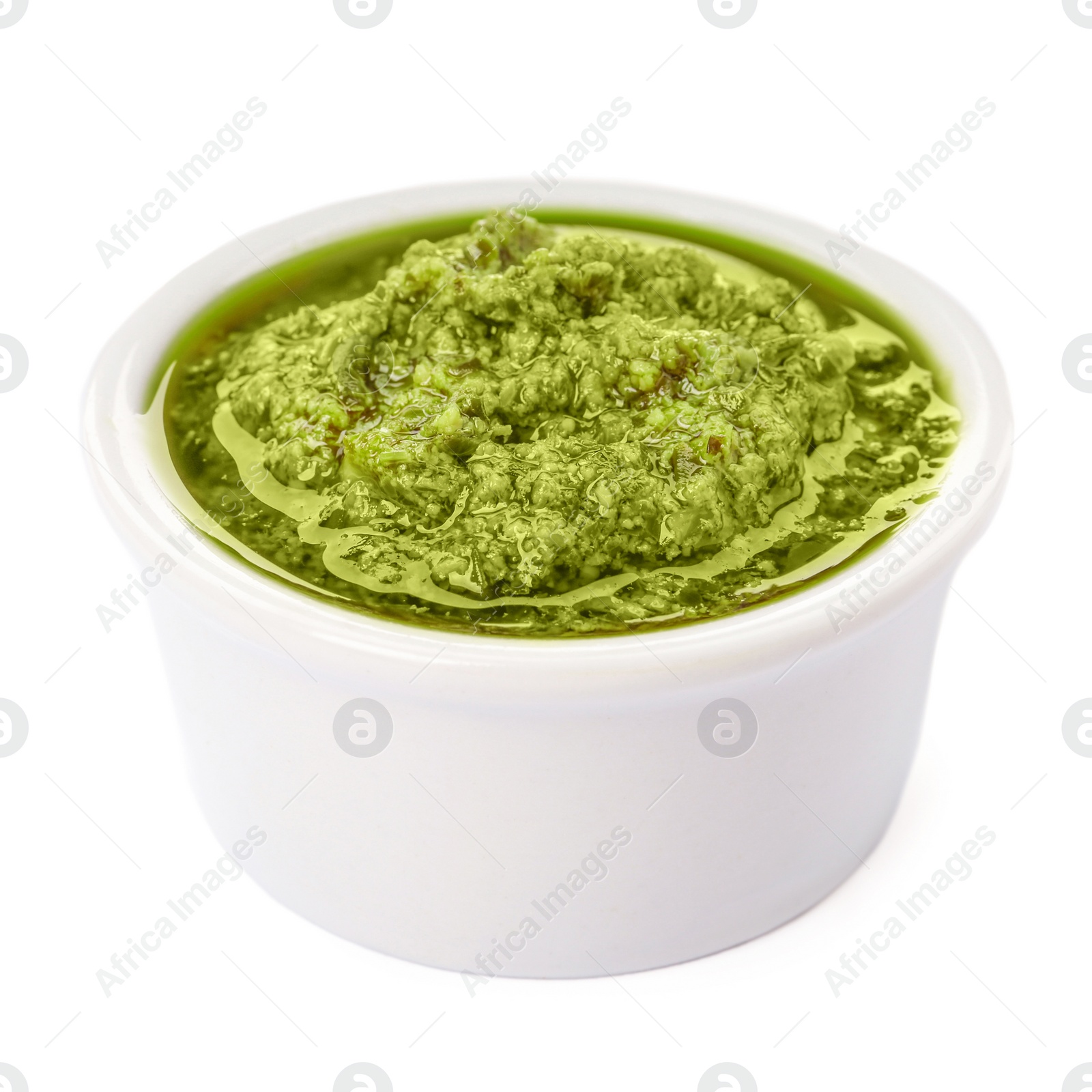 Photo of Bowl of tasty pesto sauce isolated on white