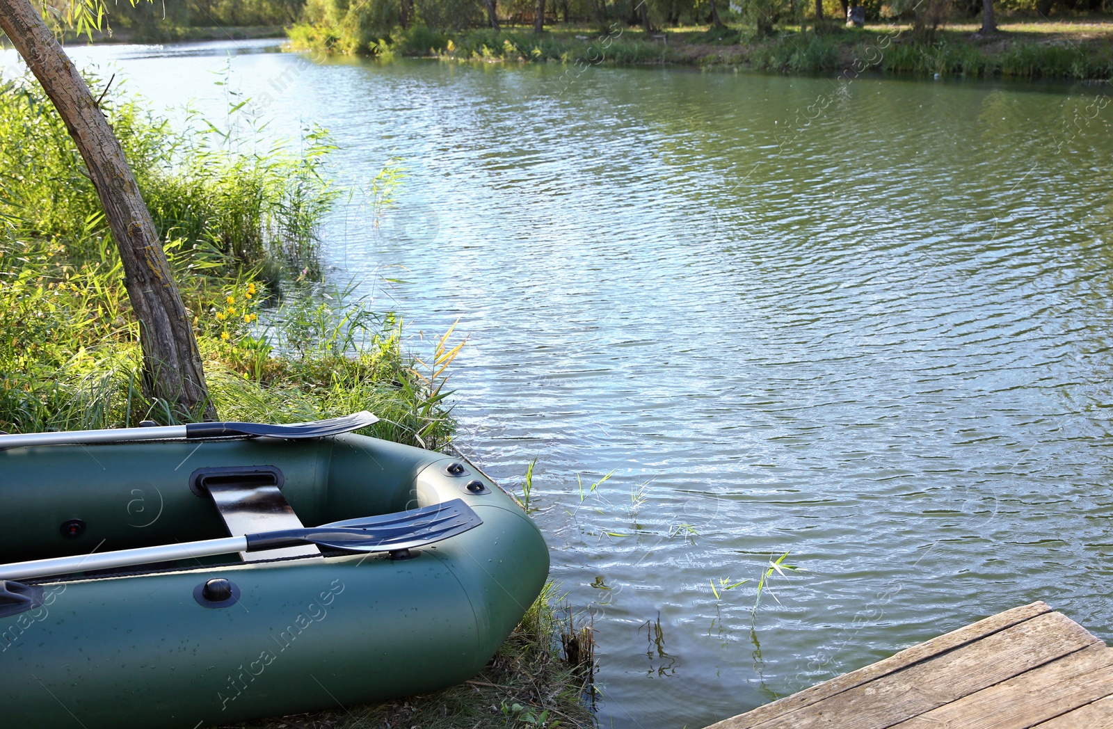 Photo of Inflatable boat for fishing near wooden pier at riverside