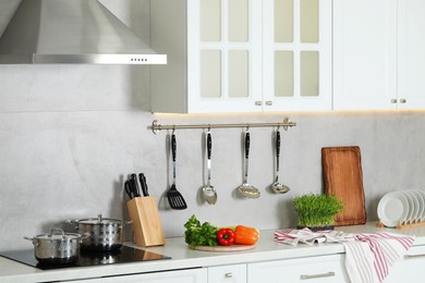 Countertop with different cooking utensils and ingredients in kitchen