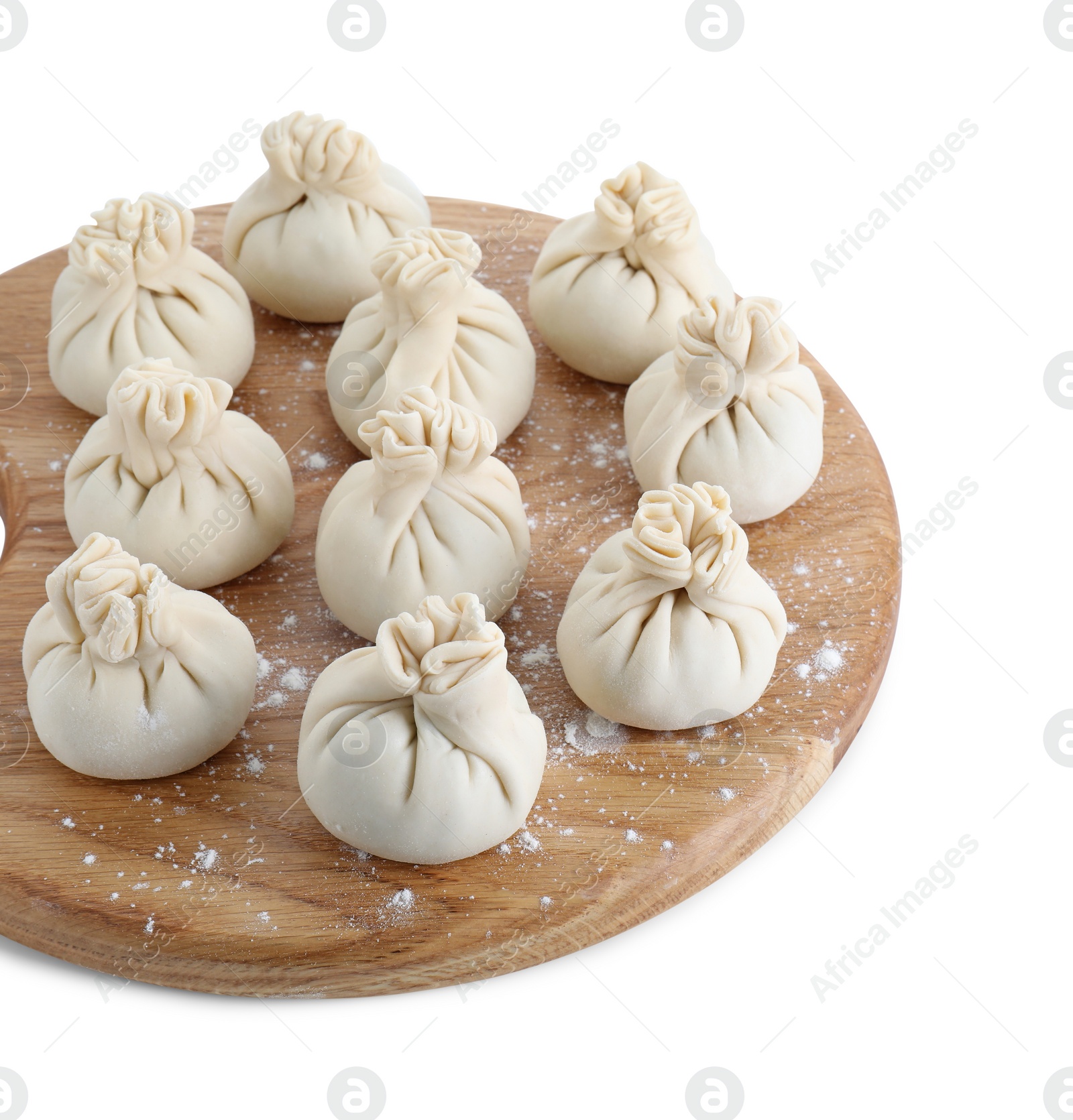 Photo of Wooden board with uncooked khinkali (dumplings) isolated on white. Georgian cuisine