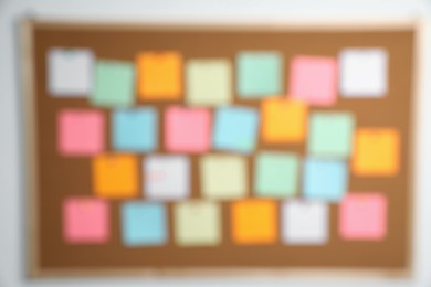 Photo of Blurred view of cork board with many colorful notes