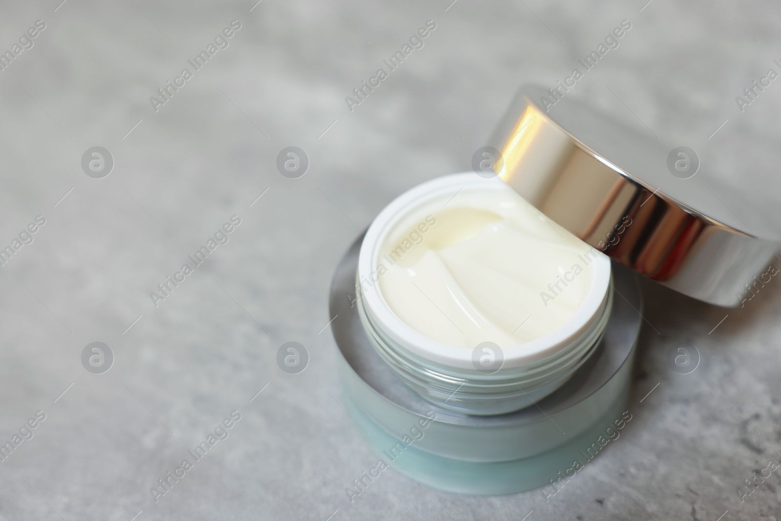 Photo of Body cream on grey table, closeup. Space for text