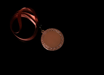 Photo of Bronze medal on black background, top view. Space for design